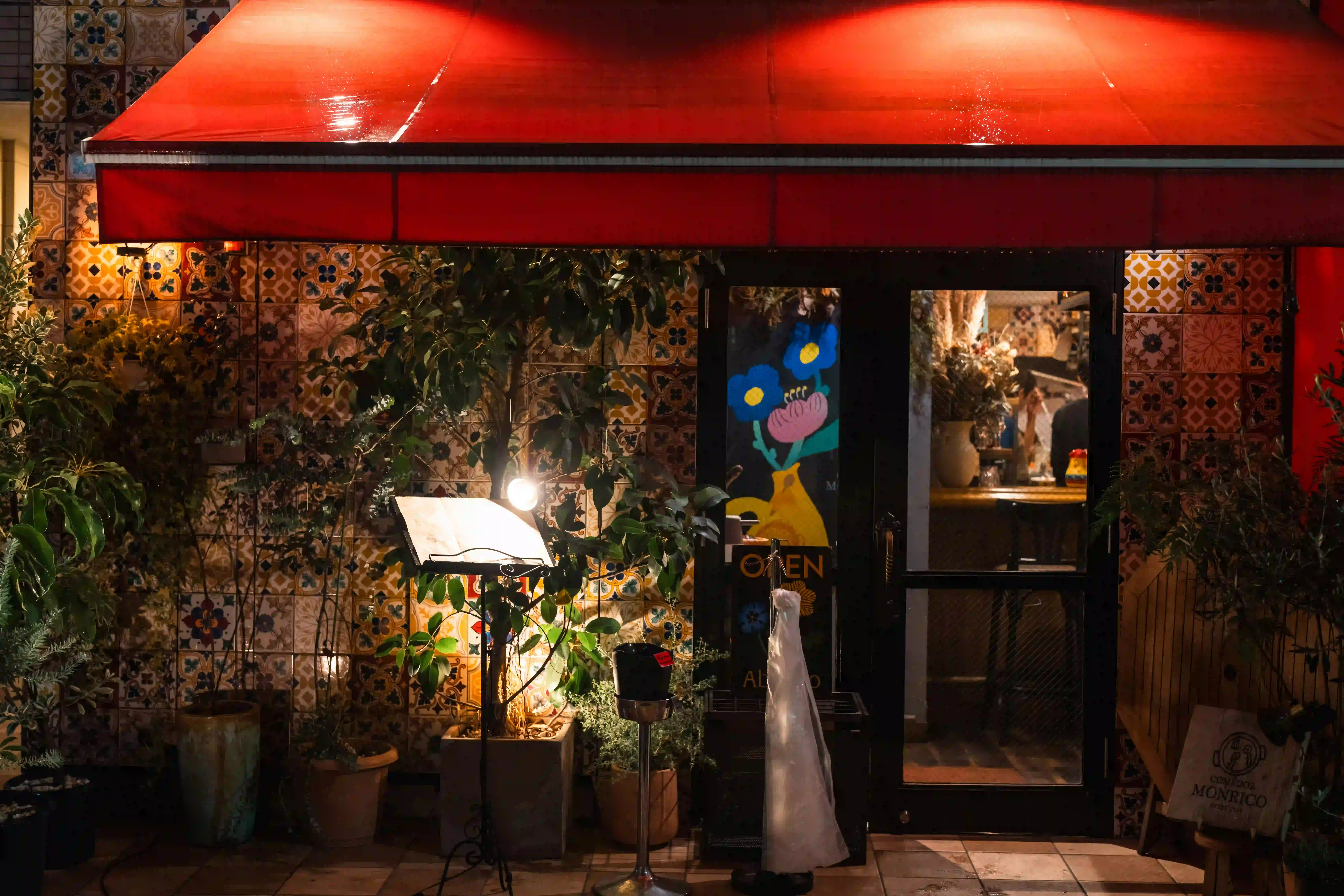 Beleuchtete rote Markise am Restauranteingang bei Nacht